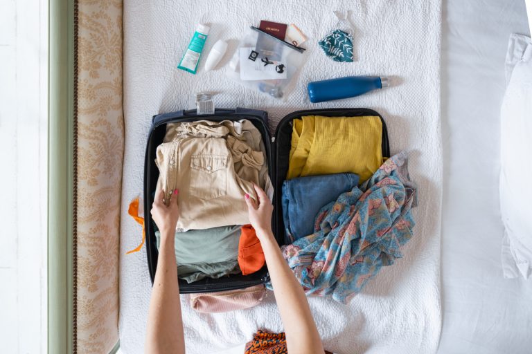 Valise ouverte avec des bagages pour les vacances d'été